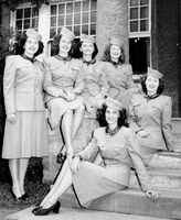 Hormel Girls in military uniforms, early troupe; 2women seated on concrete stairs and 3 on the banister. Woman on back left stands. 
